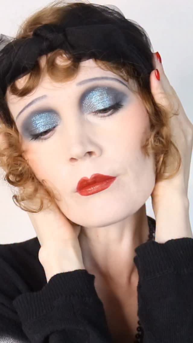 1920s Women Makeup: 9 Ideas for Lips, Eyes and Nails 7 Woman with 1920s makeup, blue eyeshadow, red lips, and a black headband.