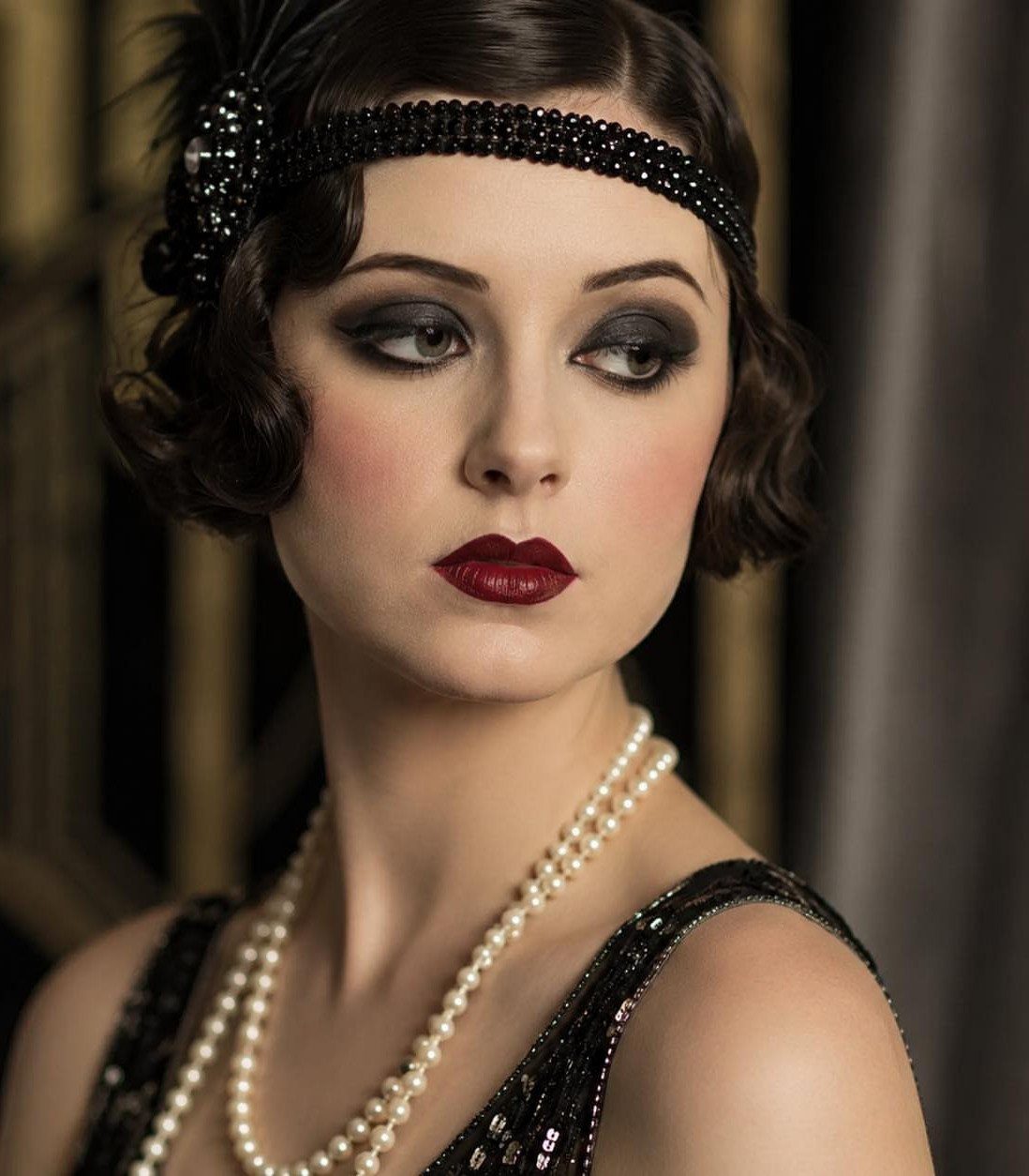 1920s Women Makeup: 9 Ideas for Lips, Eyes and Nails 1 Woman with 1920s makeup featuring red cupid's bow lips and smoky eyes.