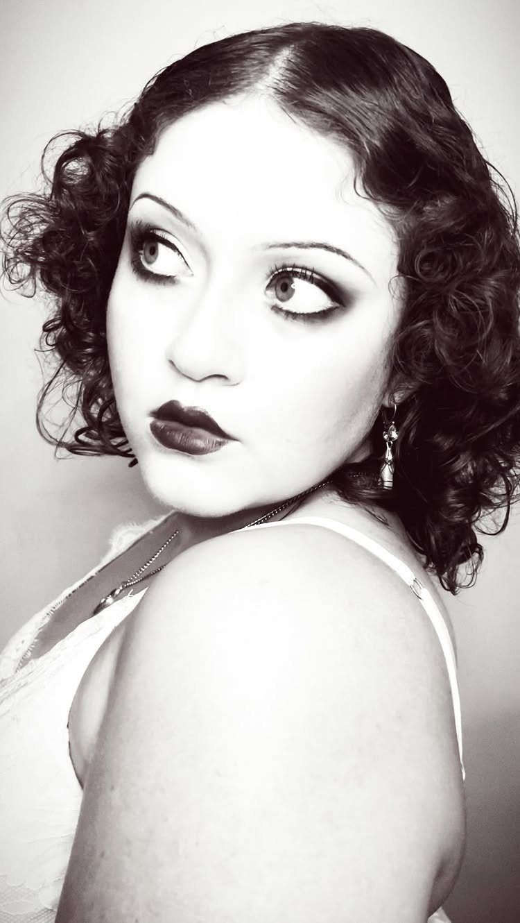 1920s Women Makeup: 9 Ideas for Lips, Eyes and Nails 4 Woman with 1920s style smoky eye makeup, thin eyebrows, and dark lips.