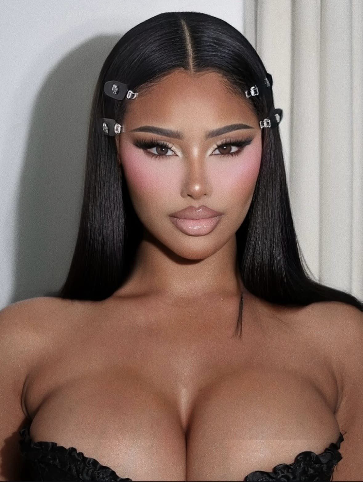 Woman with full glam makeup featuring contoured cheeks and glossy nude lips.