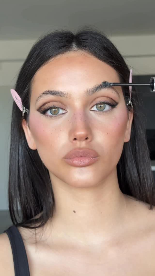 Woman with full glam makeup and faux freckles across her nose and cheeks.