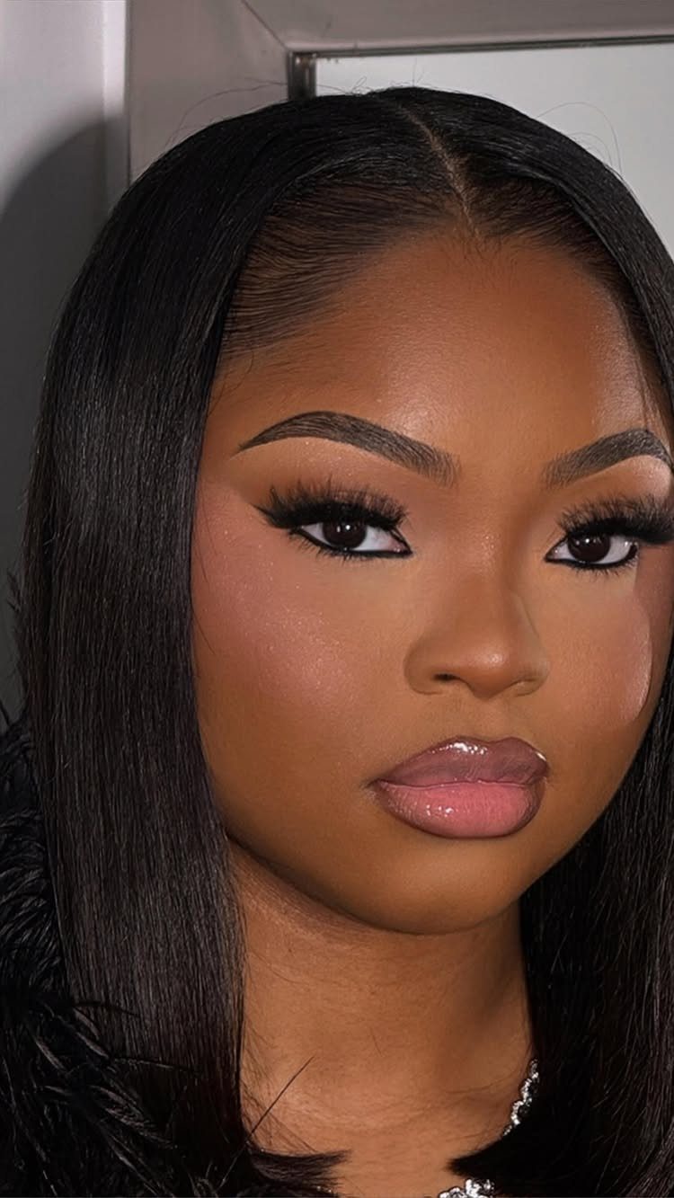 Woman with soft neutral glam makeup, winged eyeliner, and glossy nude lips.
