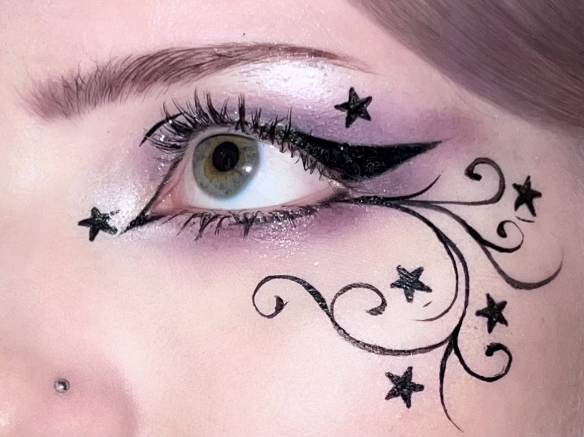 Black Purple Makeup Ideas: 5 Looks for Eyes and Lips 5 Eye with purple eyeshadow and black eyeliner featuring stars and swirling patterns.