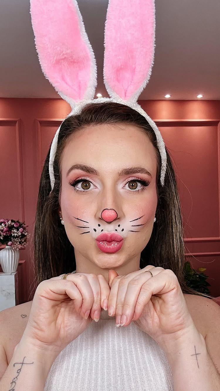 Bunny Face Makeup: 8 Ideas for Whiskers, Blush and More 4 Woman with bunny face makeup, pink ears, and black eyeliner whiskers posing.