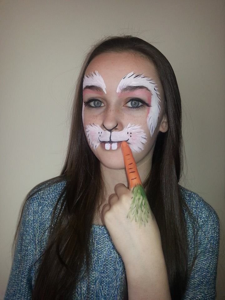 Bunny Face Makeup: 8 Ideas for Whiskers, Blush and More 2 Woman with white bunny face paint muzzle holding a carrot to her mouth