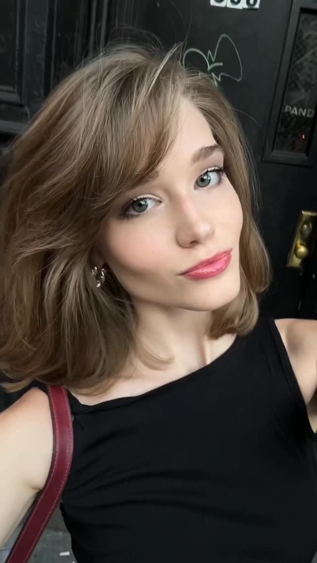 Young woman with light brown hair wearing cool toned makeup and pink lipstick.