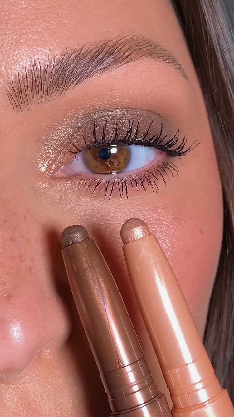 Daily Smokey Eye Ideas: 9 Looks for Every Day 2 Close-up of shimmering eyeshadow on an eye with two cream eyeshadow sticks.