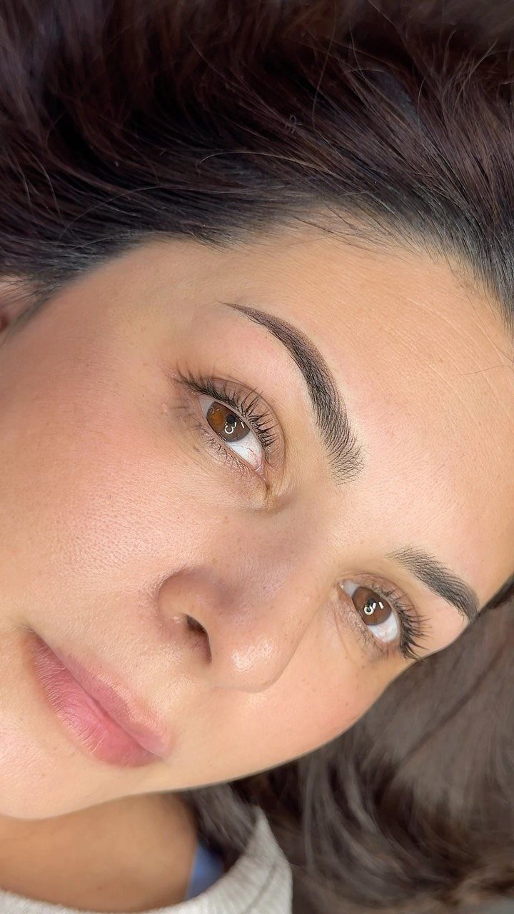 Woman's face highlighting well-defined, groomed eyebrows and natural makeup look.