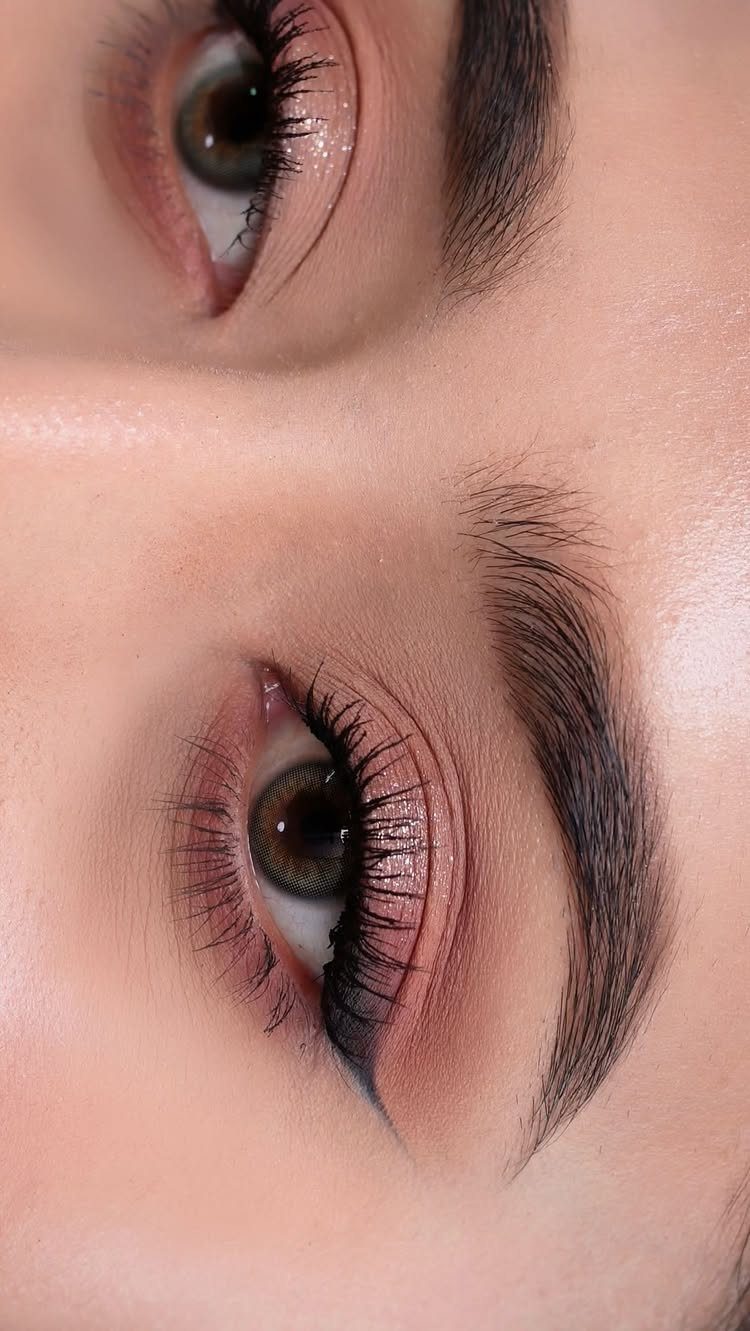 Eyes with soft brown eyeshadow, long mascara, and defined dark eyebrows.