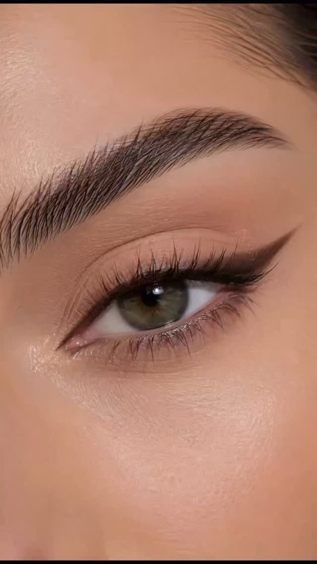 Close-up of an eye with sharp brown winged eyeliner and neutral eyeshadow.