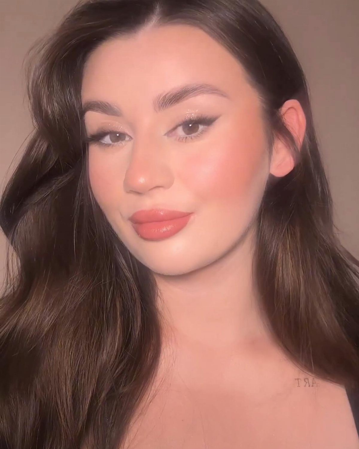 Woman with glam makeup featuring shimmery champagne eyeshadow and winged black eyeliner.