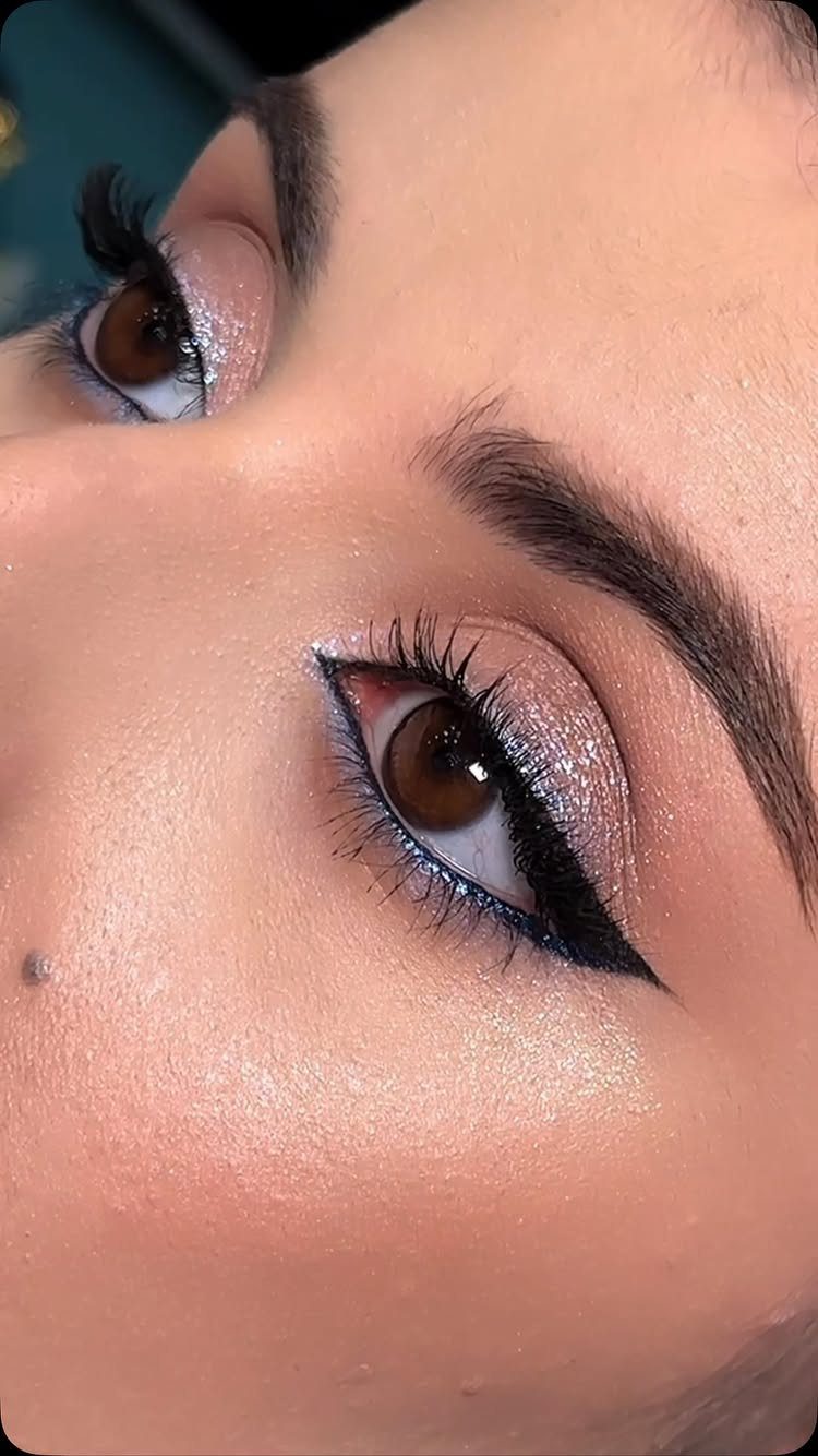 Eyes with shimmery rose gold eyeshadow and sharp black winged eyeliner.