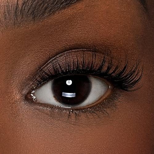 Close-up of an eye with long, voluminous black false eyelashes and dark skin.