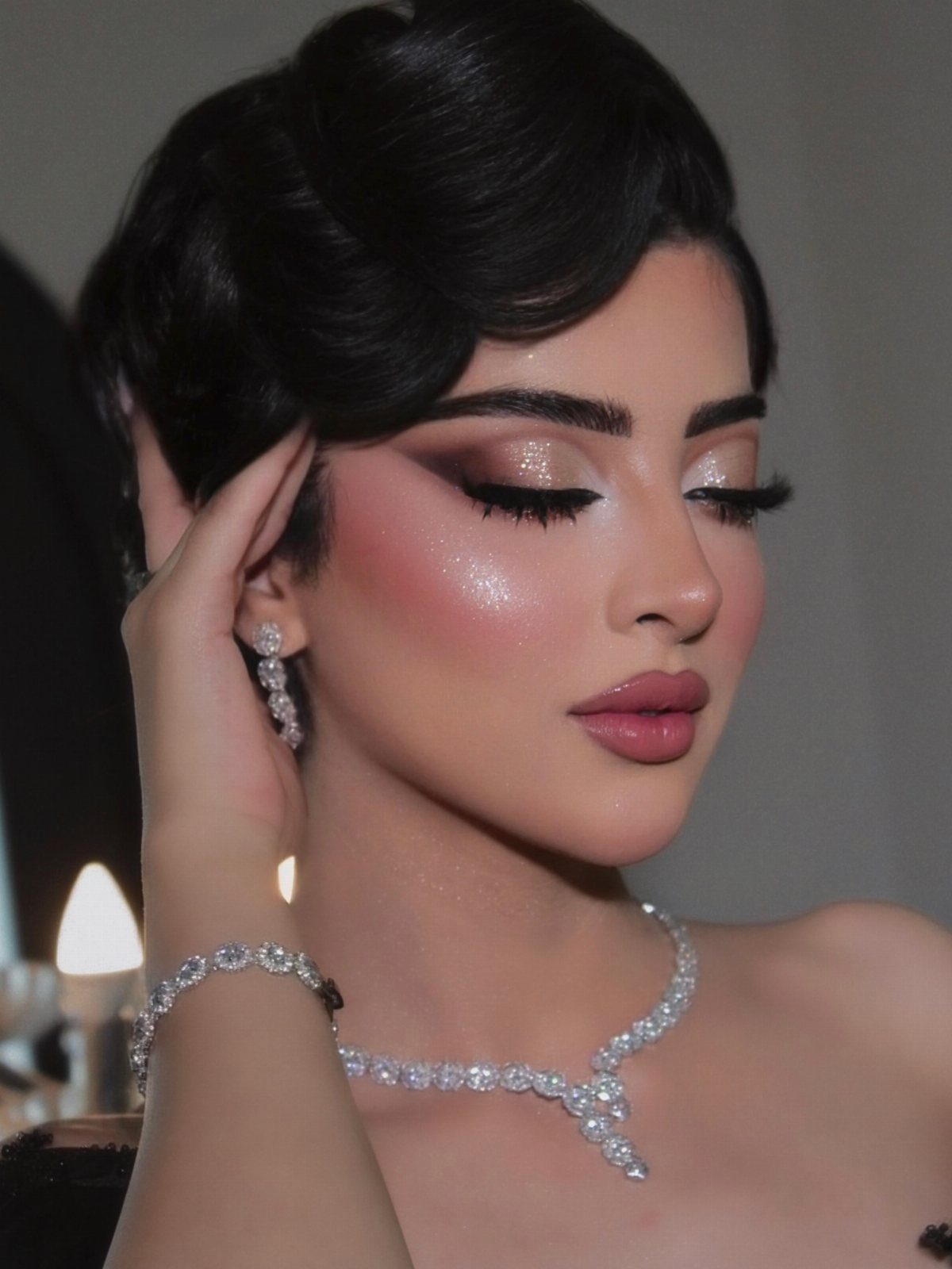 Woman with shimmering bronze eyeshadow, pink blush, and elegant diamond jewelry.