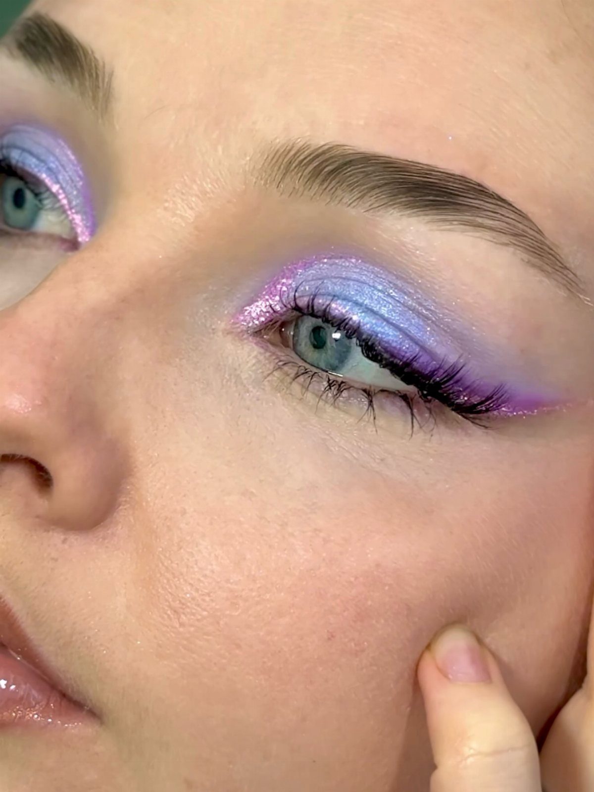 Eye makeup with shimmering purple and light blue eyeshadow in a soft aura gradient.