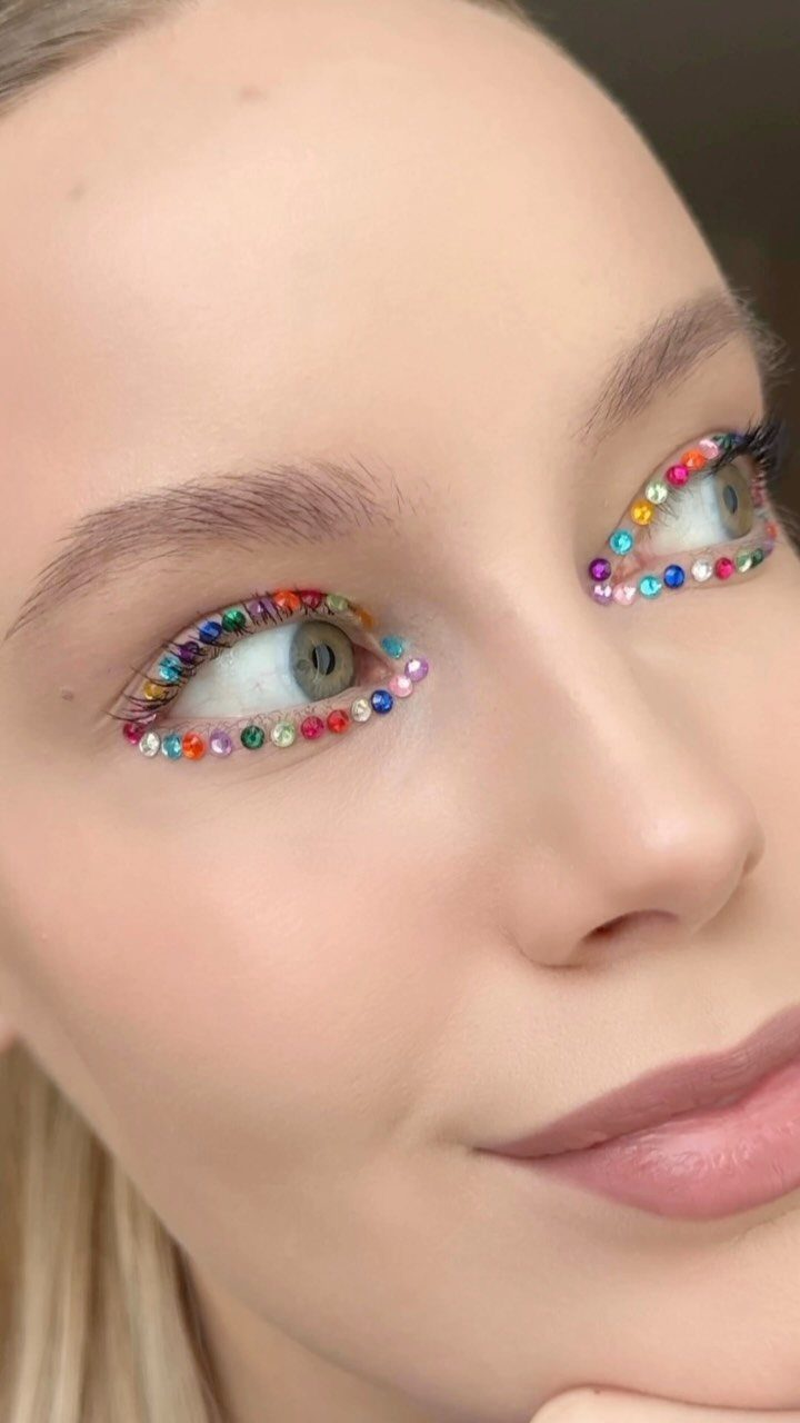 8 Eye Gem Ideas for Sparkly Party Makeup Looks 6 Woman's eyes decorated with colorful rhinestones along the upper and lower lash lines.