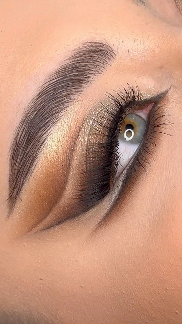 Eye Makeup for Sunken Eyes: 5 Ideas That Add Volume 5 Close-up of eye makeup with gold eyeshadow and winged eyeliner on a person