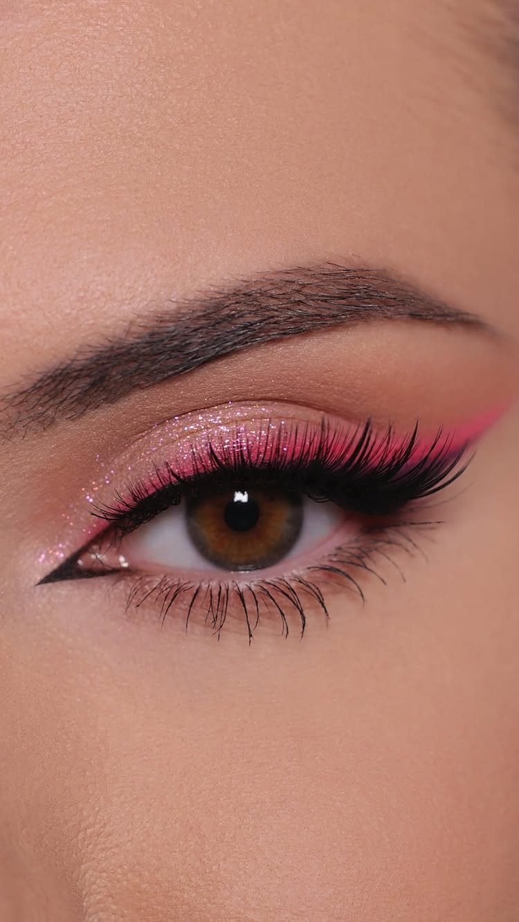 Eye with shimmering pink eyeshadow and bright neon pink winged eyeliner.