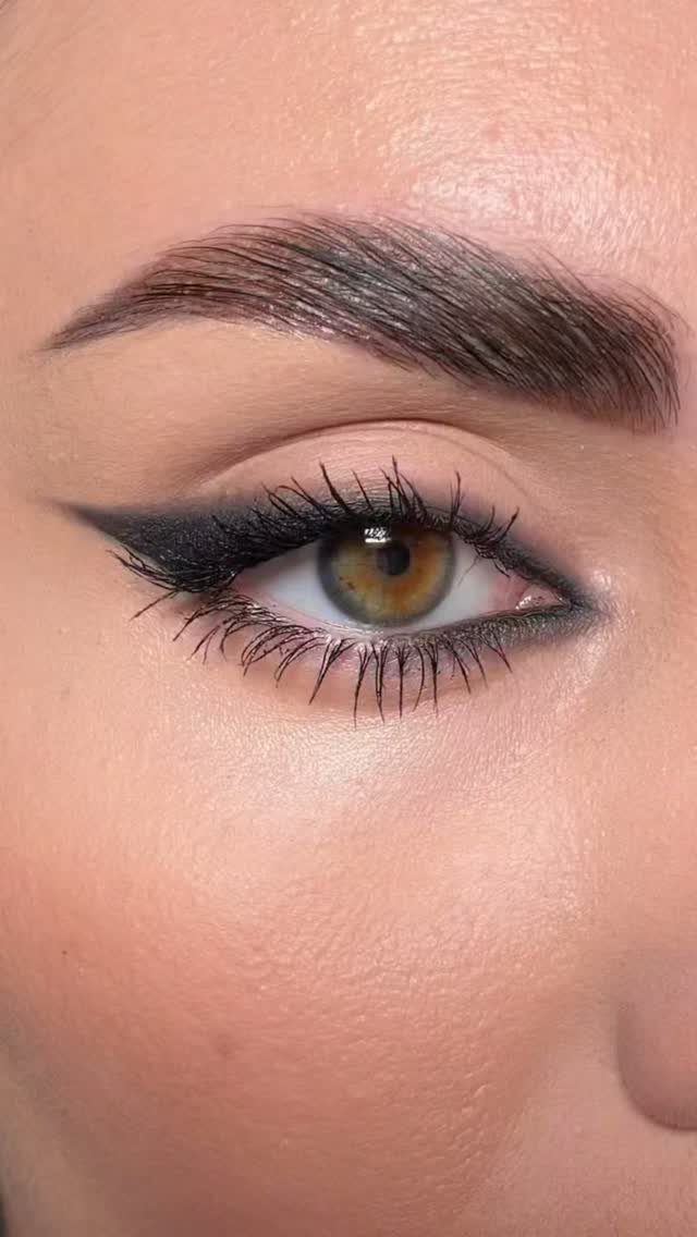Close-up of an eye with black winged eyeliner and long dark mascara lashes.