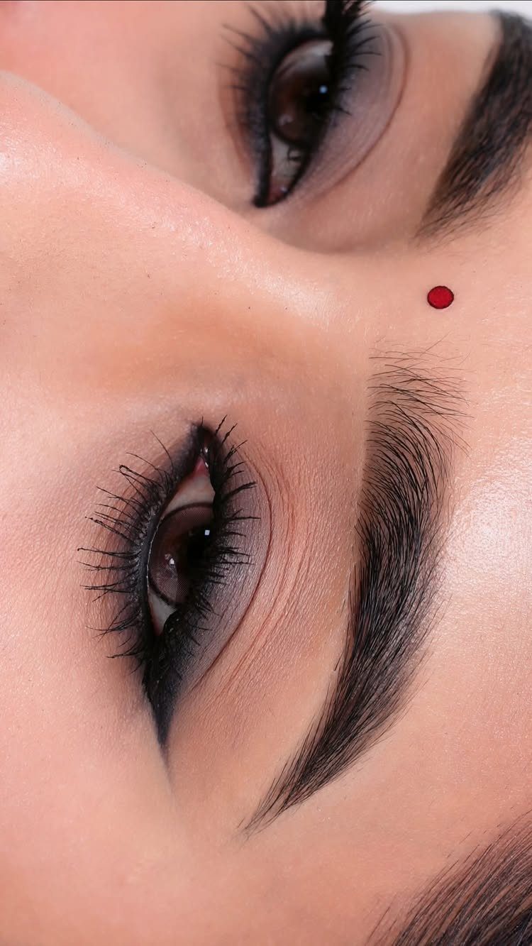 Eyes with dark smokey eyeshadow and a sharp black winged eyeliner look.