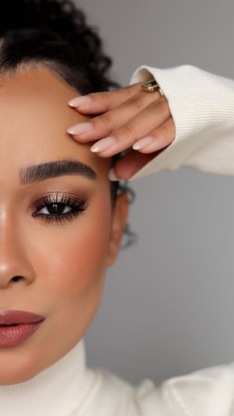 Woman with smokey eye makeup, shimmery bronze eyeshadow, and long black mascara lashes.