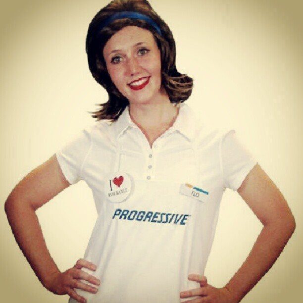 Woman dressed as Flo from Progressive wearing a white polo and blue headband.