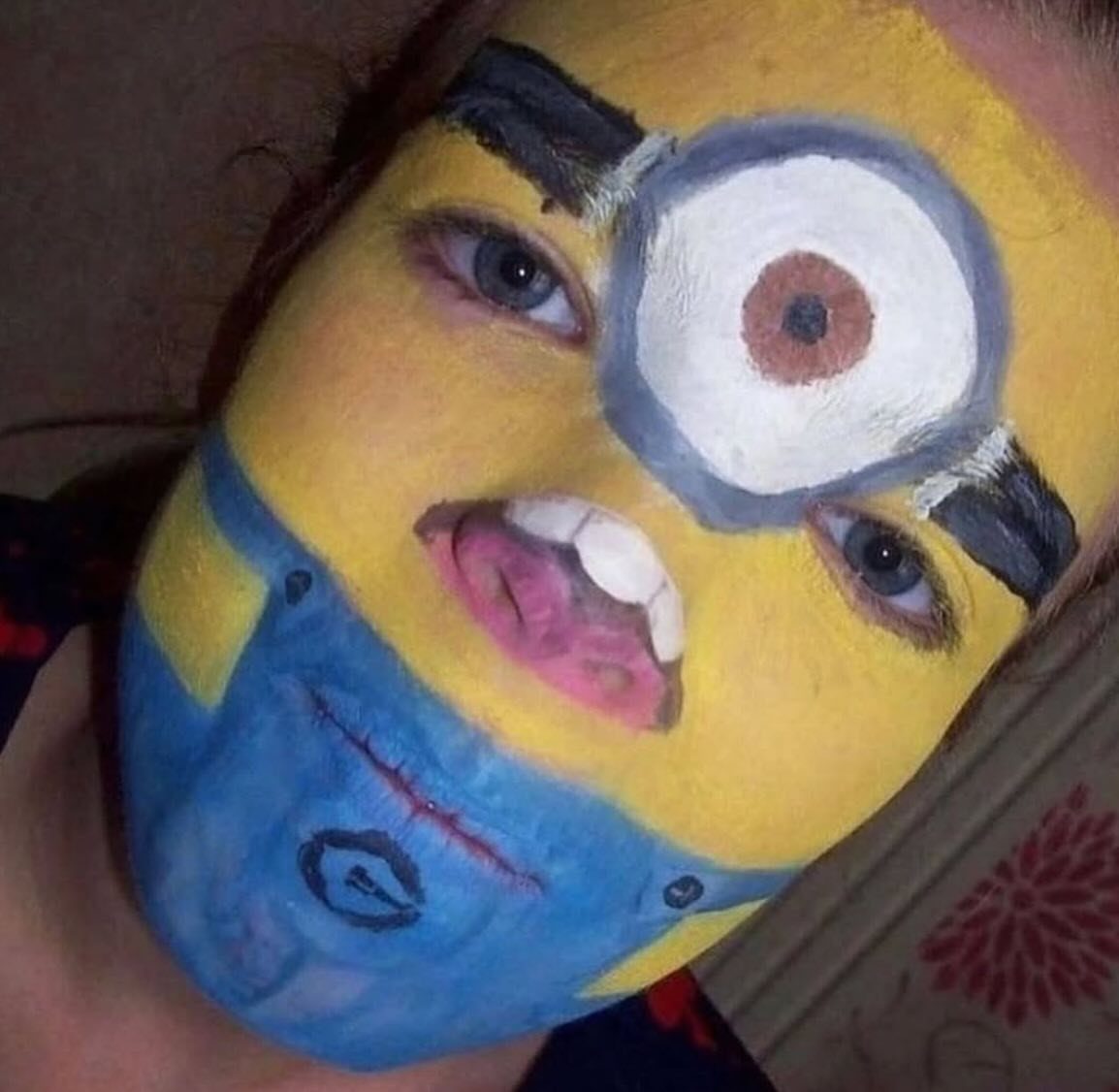 Person with face paint resembling a yellow and blue Minion character