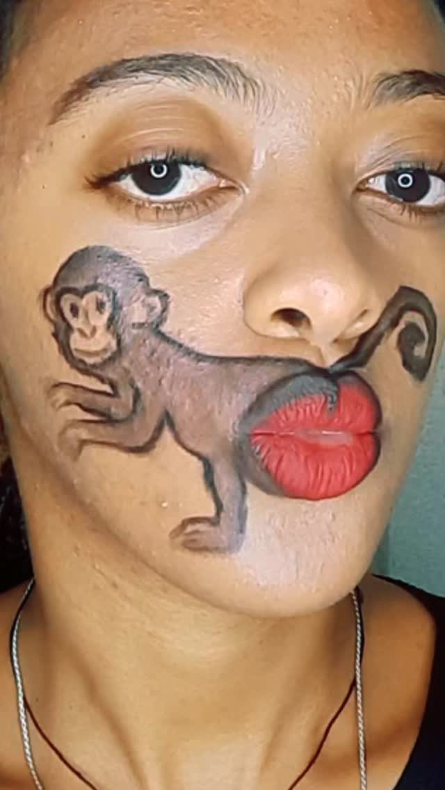 Person with makeup art of a monkey using red lips as its rear