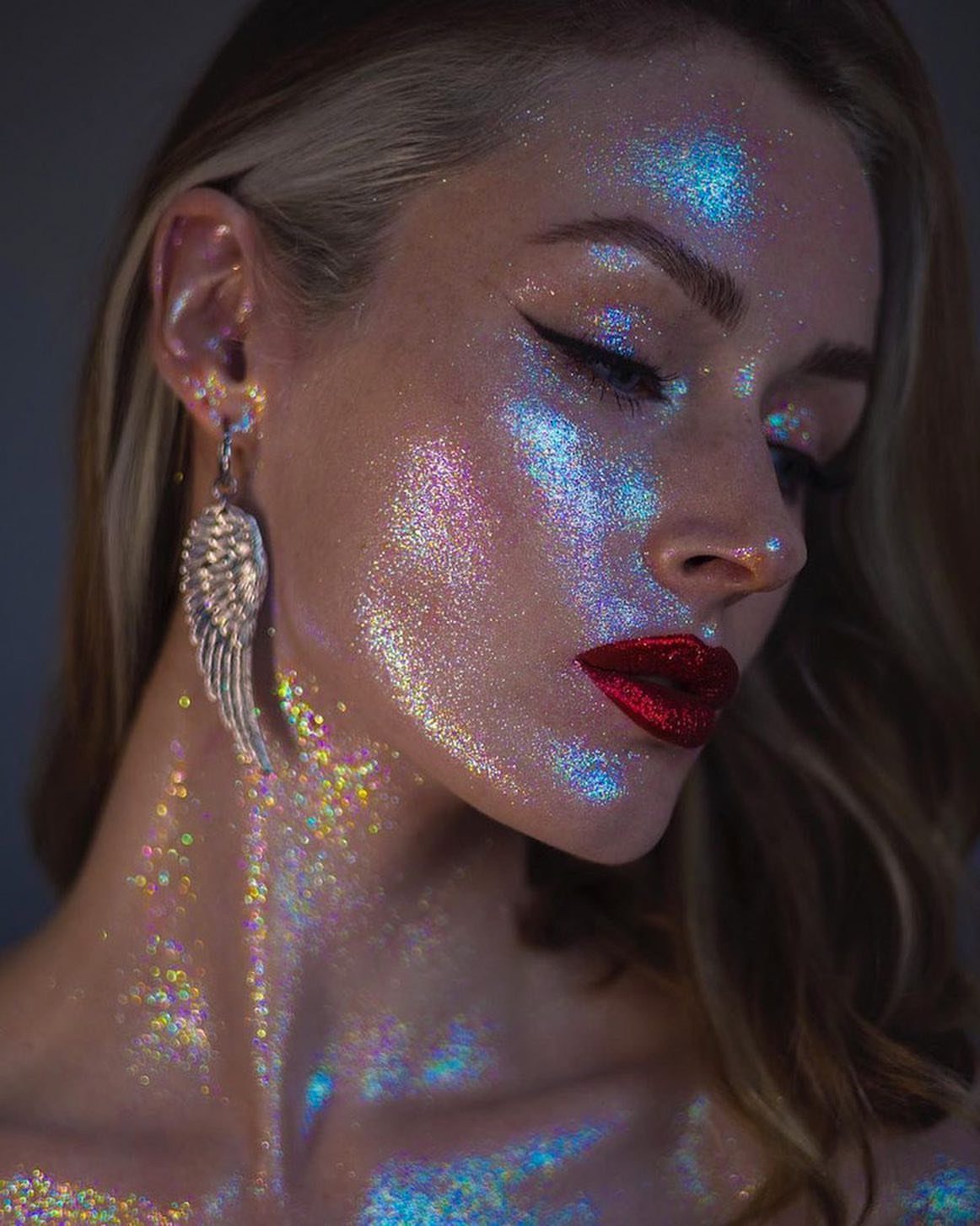 Glitter on Face Ideas: 19 Looks, From Freckles to Skulls 10 Woman with red lips and iridescent holographic glitter covering her face and neck