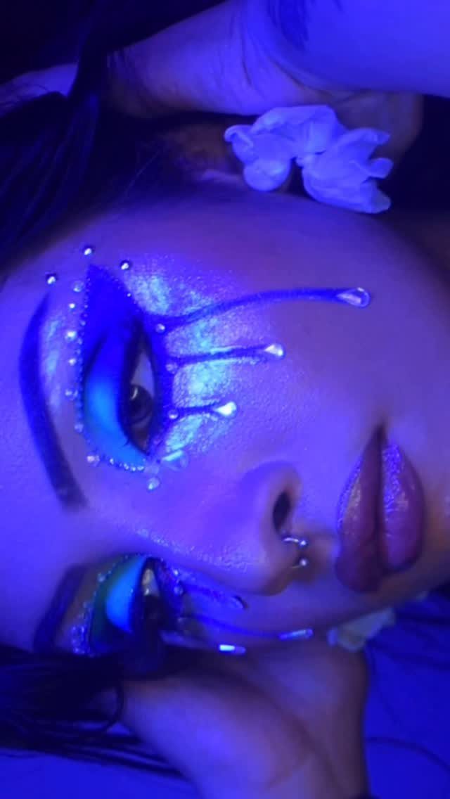 Glitter on Face Ideas: 19 Looks, From Freckles to Skulls 5 Person with blue glitter makeup applied in streaks mimicking tears under blue light