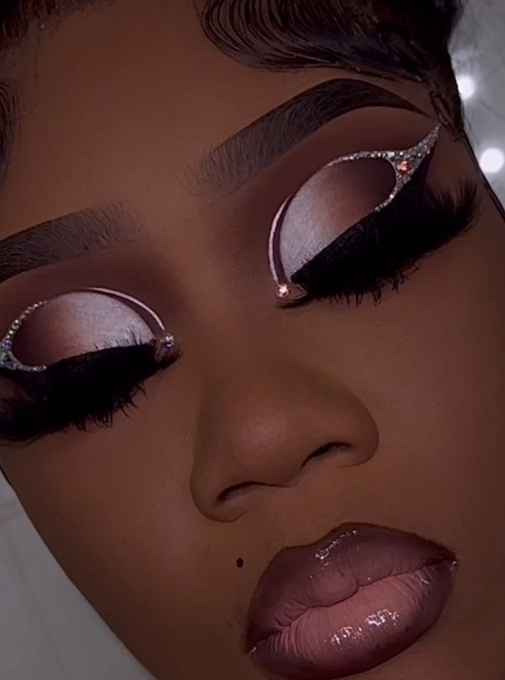 Glitter on Face Ideas: 19 Looks, From Freckles to Skulls 17 Person with shimmering pink eyeshadow and sparkling rhinestones outlining their closed eyelids.