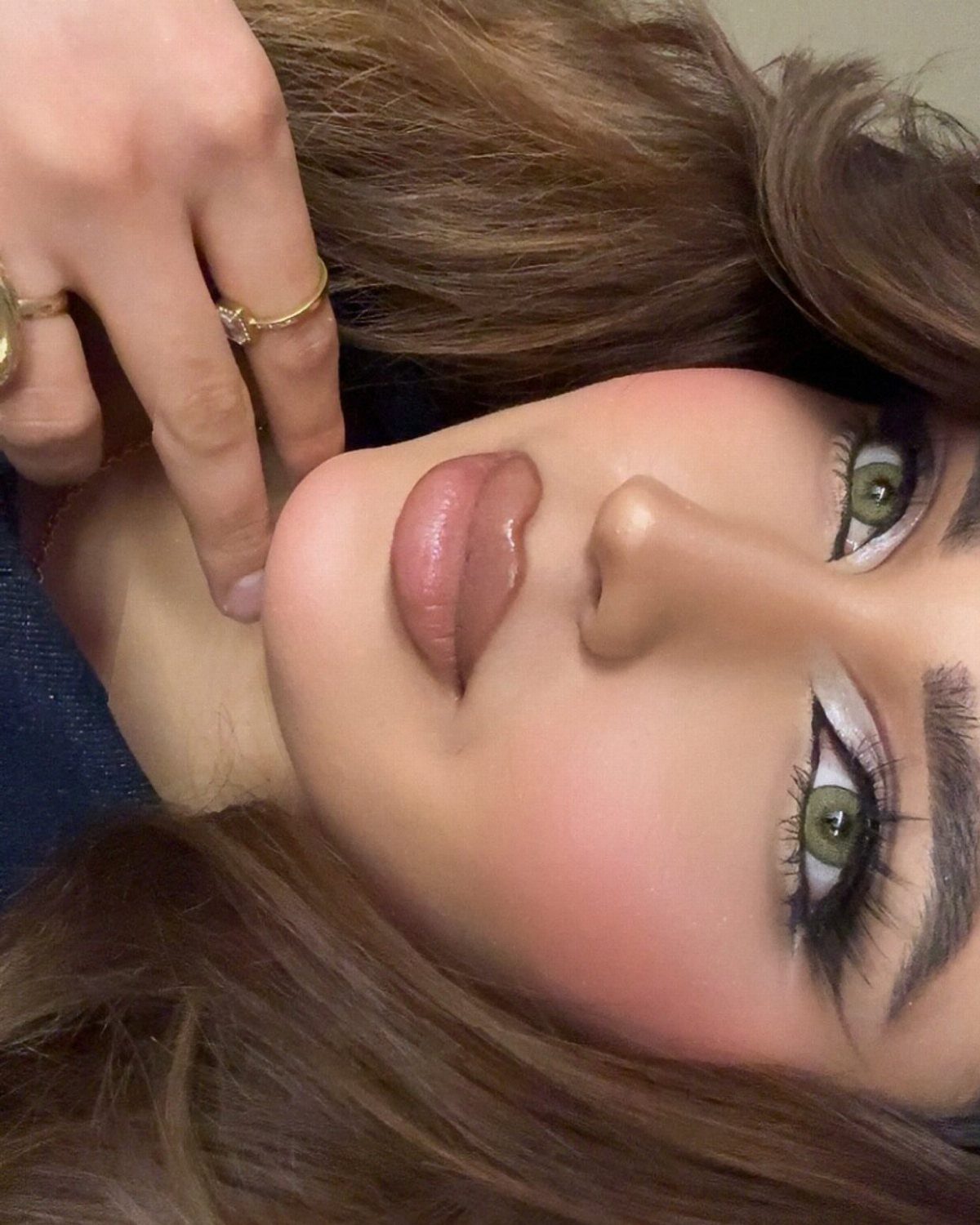 How to Do Makeup for Big Eyelids: 7 Ideas to Try 6 Woman with dramatic eye makeup, thick eyeliner, and long lashes posing for a portrait