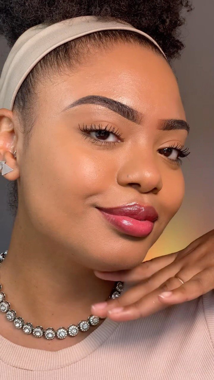 How to Do Makeup for Big Eyelids: 7 Ideas to Try 4 Woman with defined arched eyebrows, neutral makeup, and glossy pink lips posing.