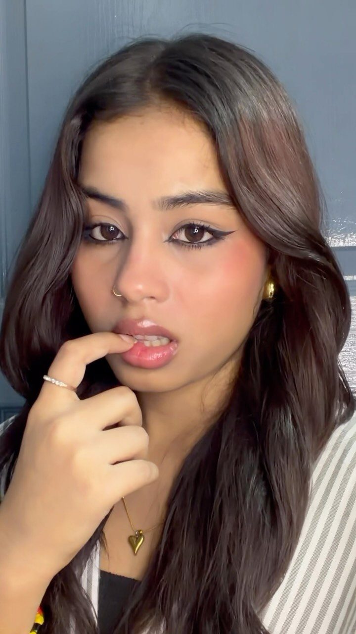 How to Do Makeup for Big Eyelids: 7 Ideas to Try 1 Woman with long brown hair wearing thick black winged eyeliner and neutral makeup.
