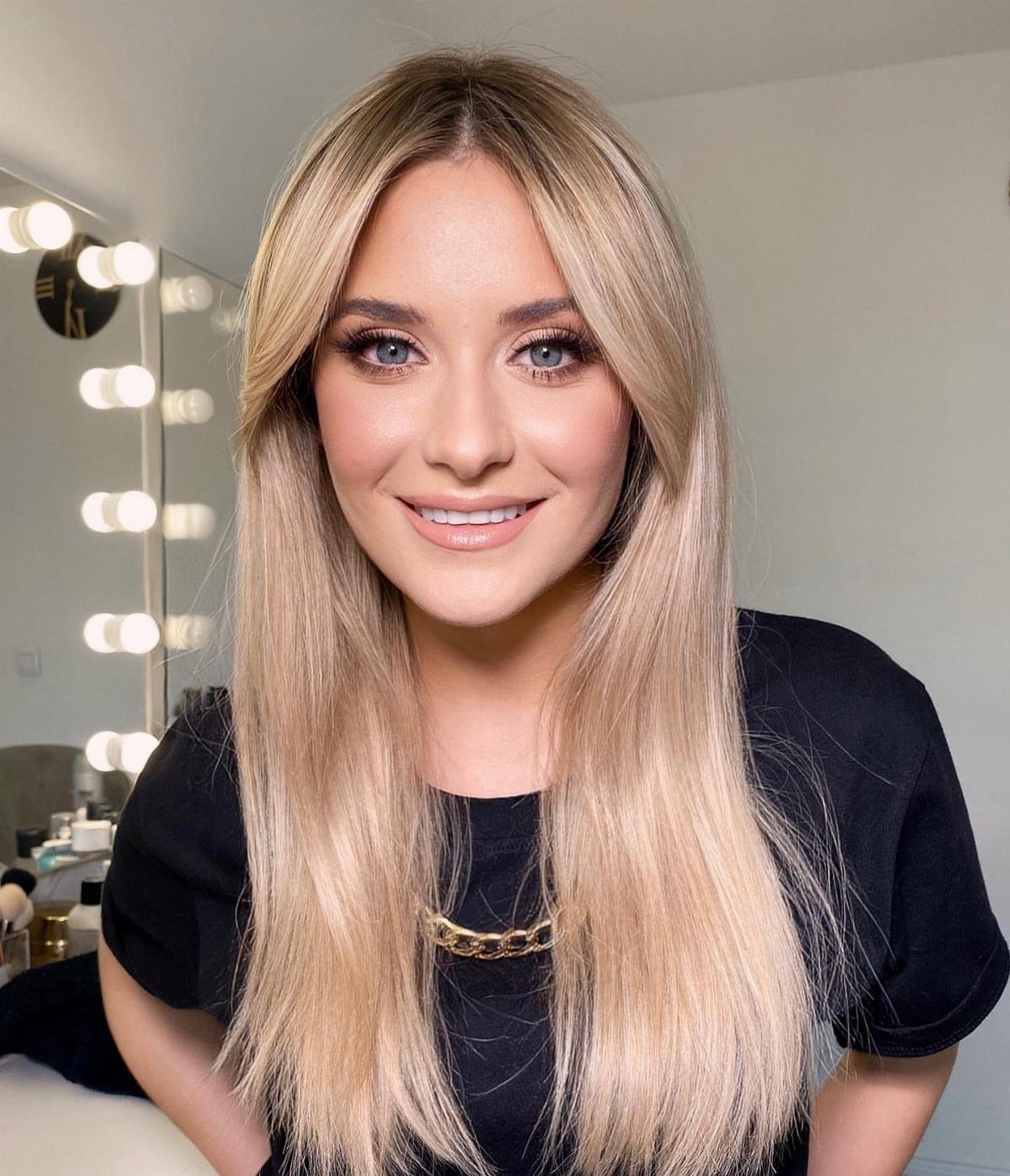 Woman with blonde hair and blue eyes wearing a full face of makeup