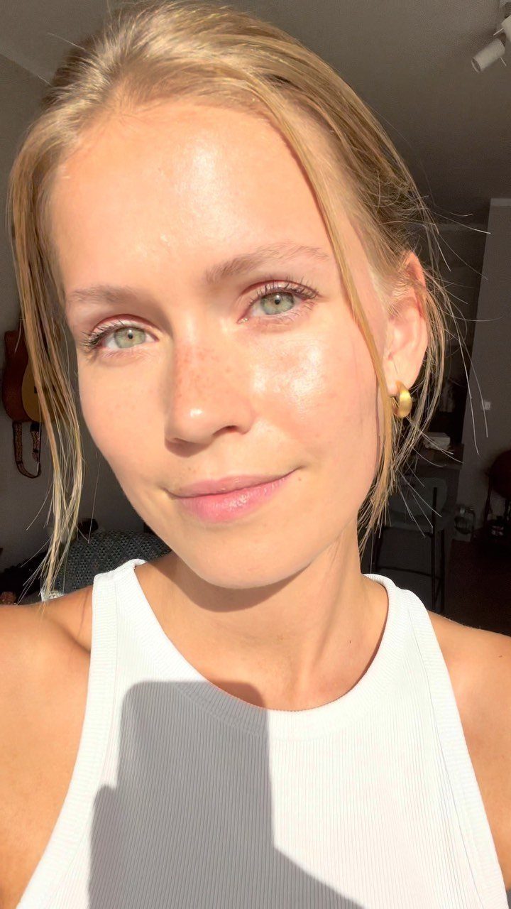Woman with blonde hair and blue eyes wearing natural, minimal makeup.