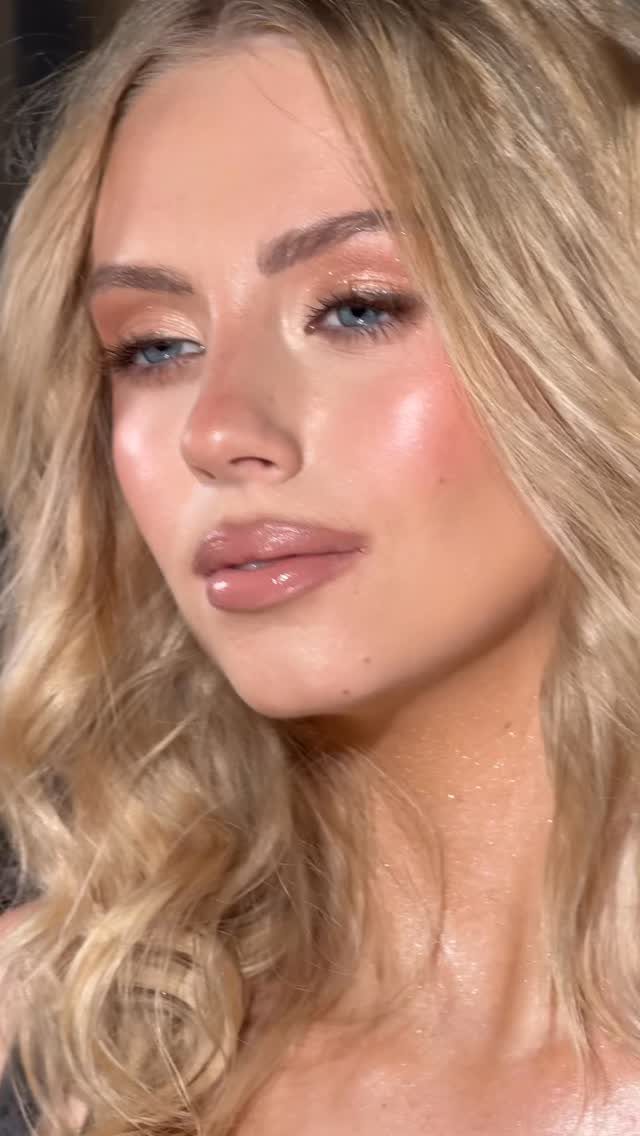 Woman with blonde hair and blue eyes wearing shimmering gold and nude makeup