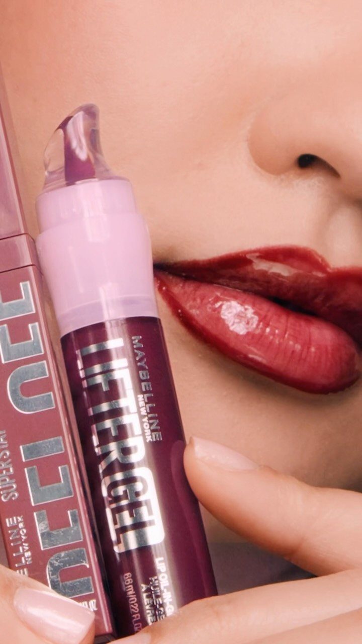 Deep berry glossy lips with a purple lip gloss tube held nearby.