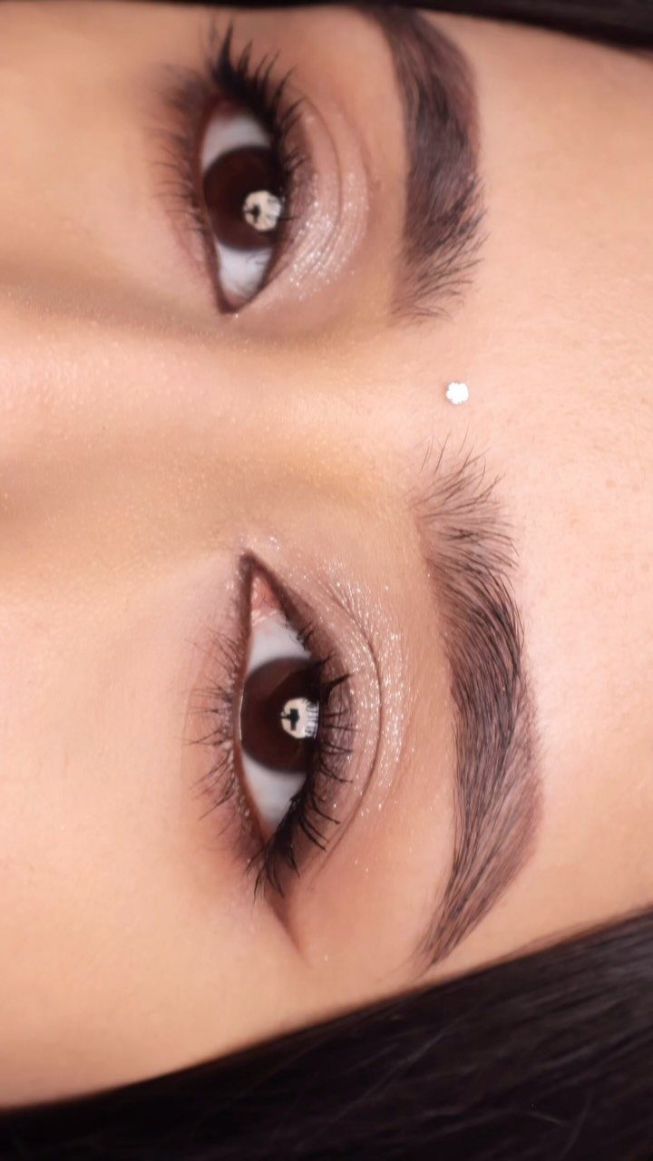 Eyes with shimmery gold eyeshadow, winged eyeliner, and long dark lashes.