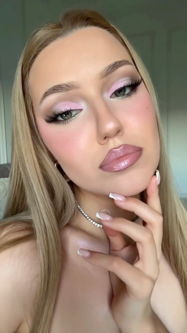Woman with blonde hair wearing pink eyeshadow and pink blush on cheeks and nose