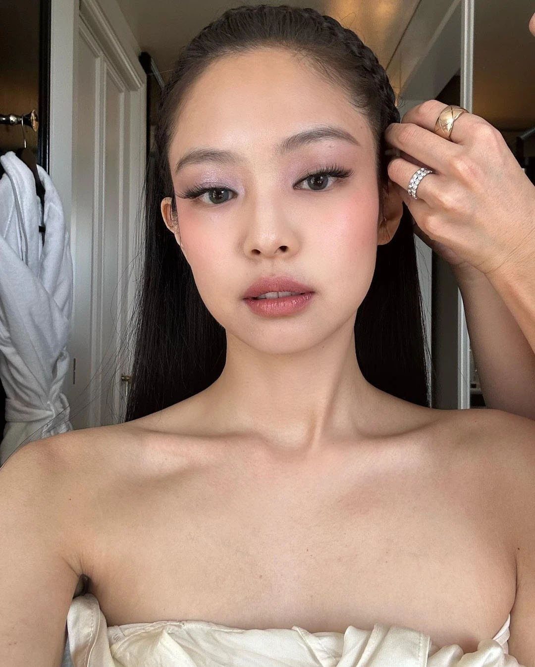 Woman with shimmering pink eyeshadow and soft pink blush posing for a portrait