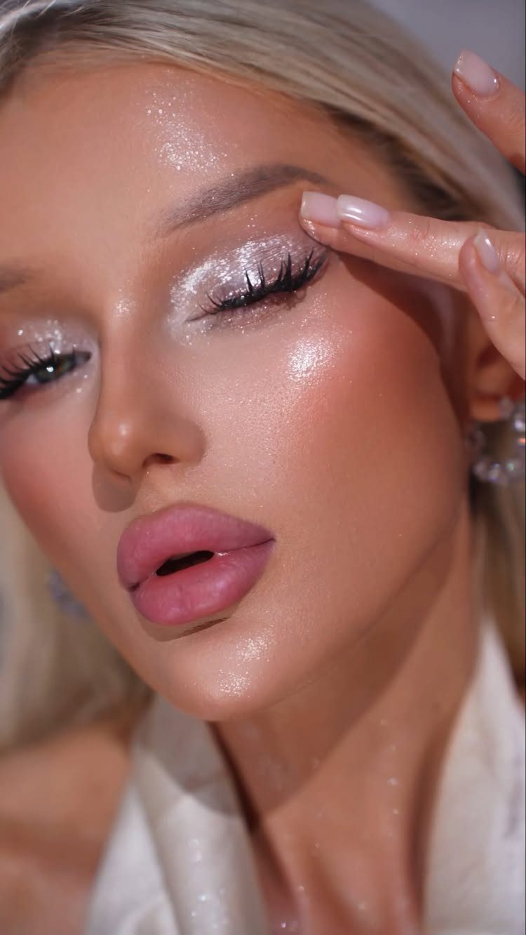 Woman with shimmering silver glitter eyeshadow and pink lips posing for a portrait