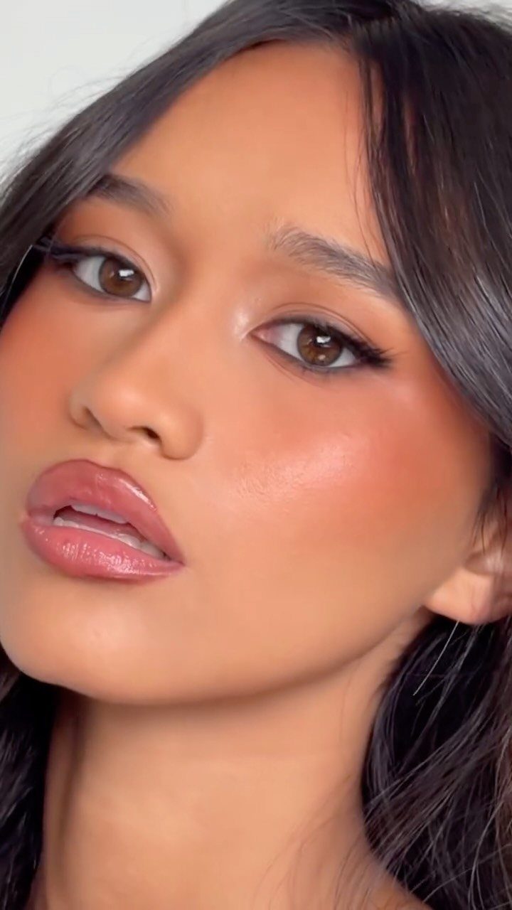 Natural Bronzy Makeup Looks: 10 Warm Glow Ideas 7 Woman with glowing bronzed makeup, shimmering eyeshadow, and glossy lips posing for portrait