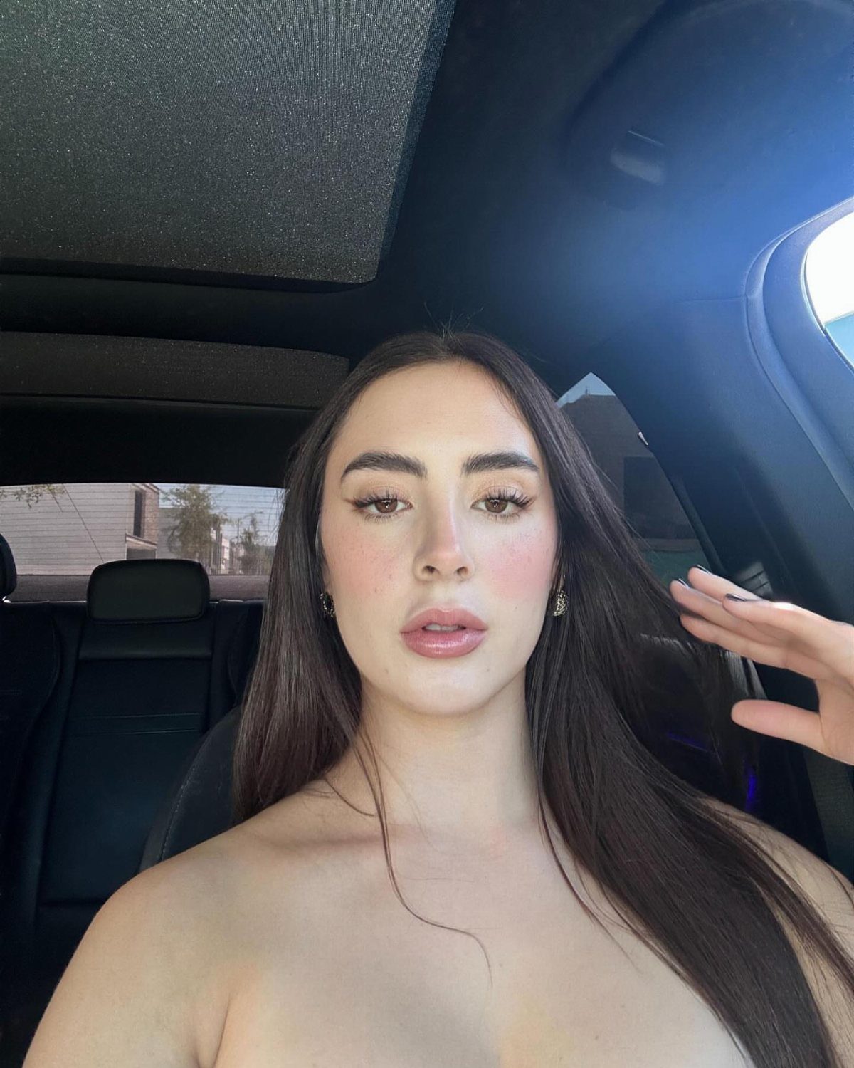 Natural Bronzy Makeup Looks: 10 Warm Glow Ideas 3 Woman with warm peach lip color and bronzed makeup posing in a car