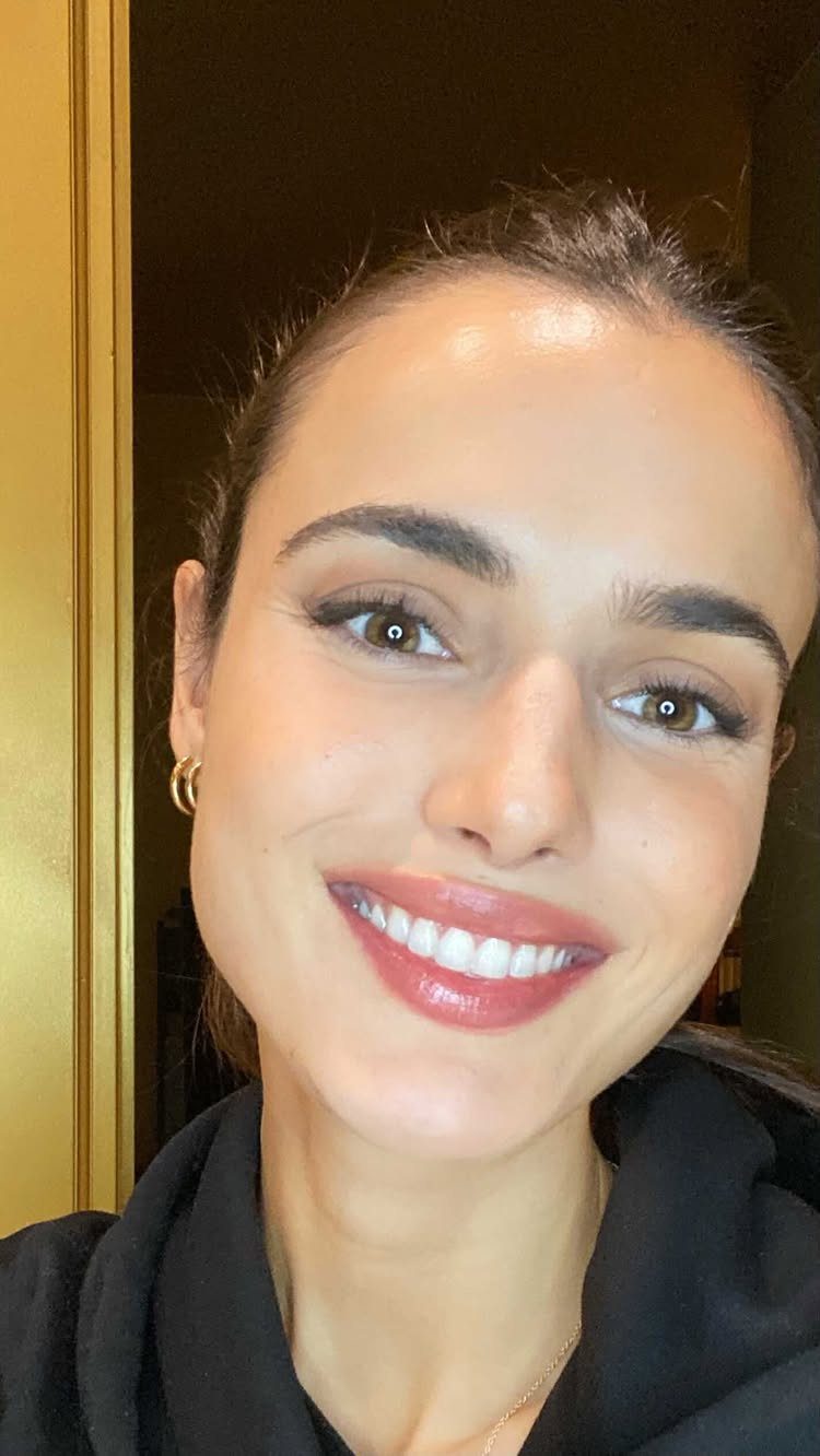 Woman with natural makeup and pink lipstick smiling for a close-up portrait