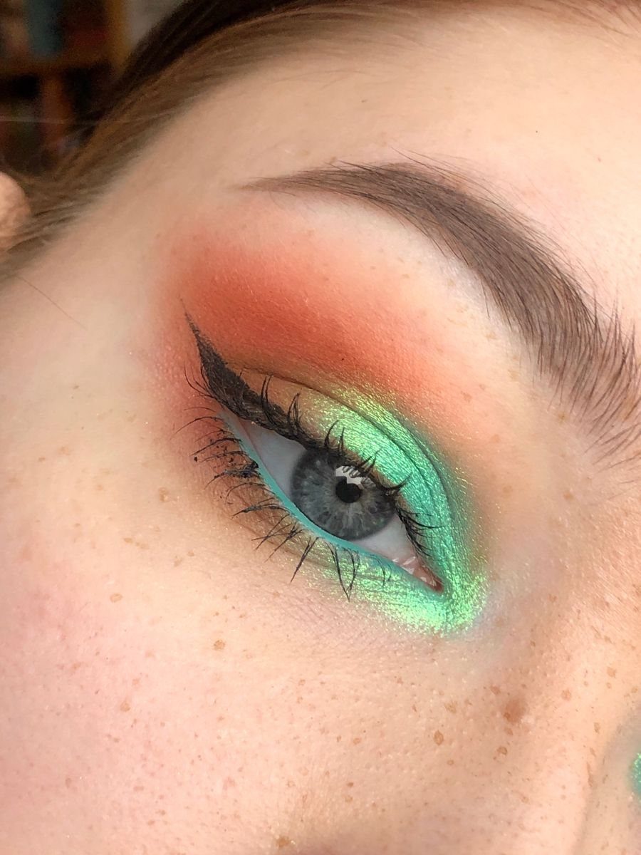 Eye makeup featuring orange and lime green eyeshadow with bold black winged eyeliner.