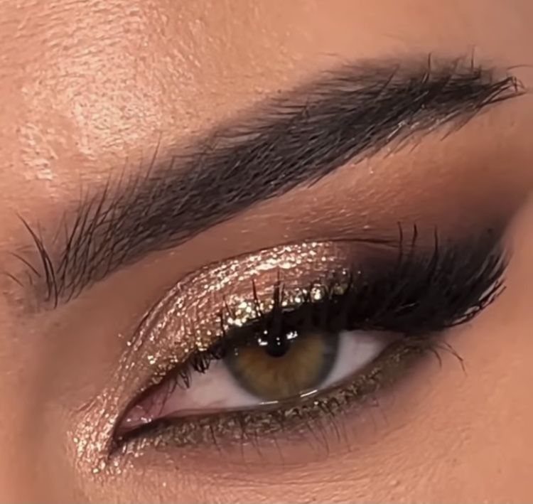 Eye with gold glitter eyeshadow and dark smoky blending for prom makeup.