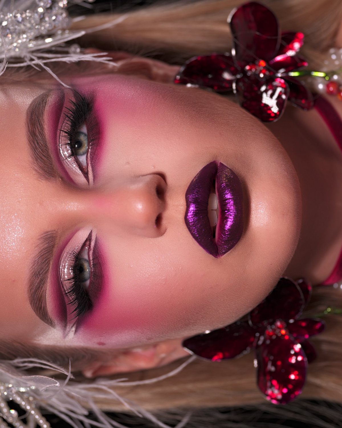 Person with green eyes wearing bold burgundy eyeshadow and metallic burgundy lipstick.