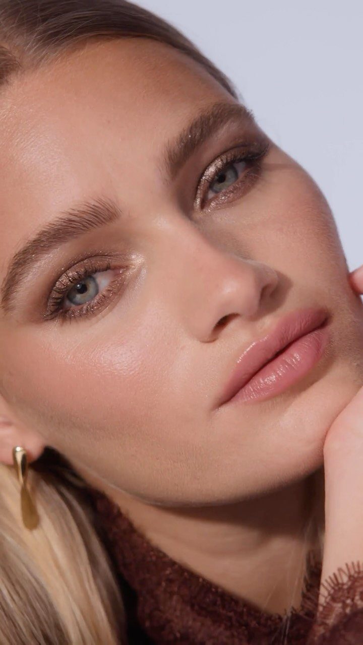 Woman with green eyes wearing champagne and chocolate shimmering eyeshadow and glossy lips.