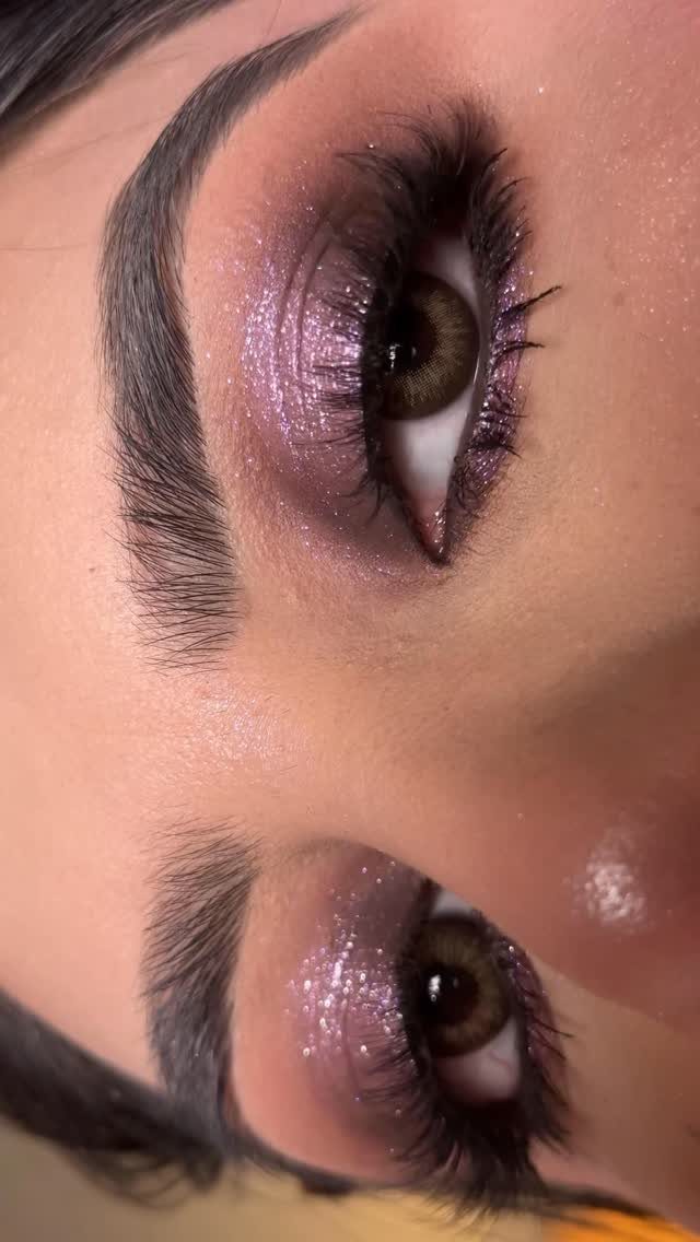Eyes with shimmering mauve and purple eyeshadow and long dark eyelashes.